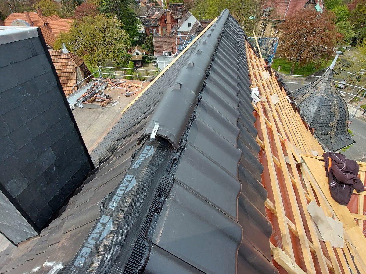 Dach im Bau: neue Ziegel werden auf die Lattung gelegt